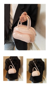 Detail view of pink glossy leather handbag with wavy zipper and detachable strap
