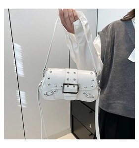 Detail of white glossy leather shoulder bag with punk silver rivets and metal buckle