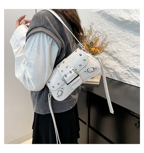 Vue détaillée du sac à bandoulière en cuir blanc avec rivets et boucle métalliques