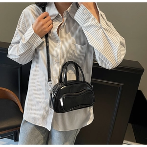Détail macro du sac noir brillant avec fermeture éclair vague argentée et fini poli