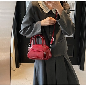 Selfie miroir d'un sac Boston rouge brillant avec ferrures argentées et bandoulière