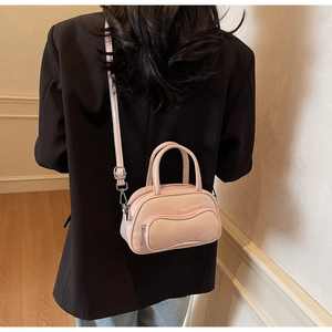 Pink mini bowling bag crossbody styled with a black blazer on a model side view
