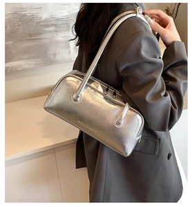 Detail of silver metallic Boston bag featuring cracked texture and embossed logo