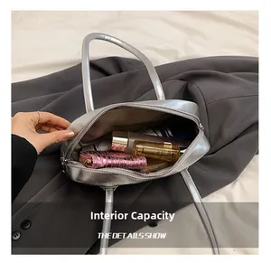 Internal capacity of silver metallic shoulder bag showing makeup and phone storage