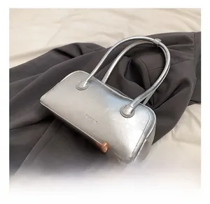 Close-up of metallic silver Boston bag texture and SHIYUBAG logo on grey blazer