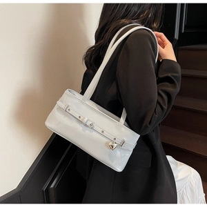 Détail du sac à bandoulière gris brillant avec pendentif cœur argenté et sangle décorative