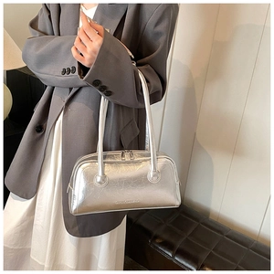 Detail of metallic silver baguette bag showing vintage wrinkled texture and zip closure