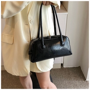 Detail view of black wrinkled patent leather Boston bag featuring SHIMUBAG logo embossing