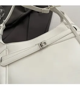 Detail of white leather tote bag featuring a silver rectangular twist lock and dual stitching