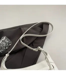 Detail of adjustable white leather strap with silver metal buckle on a retro tote bag