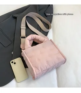 Rosafarbene gesteppte Daunentasche mit Handy zum Größenvergleich abgebildet