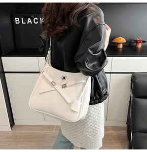 Detail showing the white leather tote bag with silver buckle and crossbody strap detail