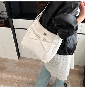 Detail showing the white bucket bag with a silver buckle and adjustable shoulder strap