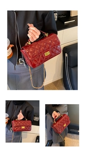 Macro shot of dark red patent leather quilted texture and gold metal chain strap on handbag