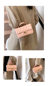Detailed view of pink quilted handbag with gold chain strap and elegant metallic twist lock