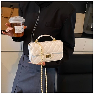 Detail of white quilted chain bag with gold square buckle and leather woven strap