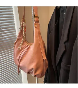 Détail du sac hobo rose avec fermeture éclair à pompon et pendentif coeur doré