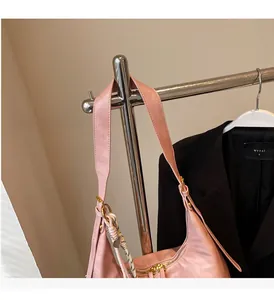 Sac hobo rose en cuir mat avec fermeture éclair dorée et breloque en corde tressée