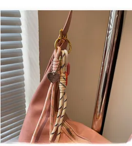 Détail du sac cabas en cuir rose avec breloque en corde et pendentif en métal