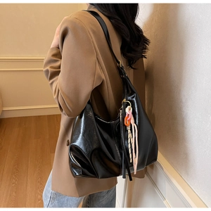 Vue latérale du sac hobo en cuir brillant noir avec détail de corde tissée sur modèle