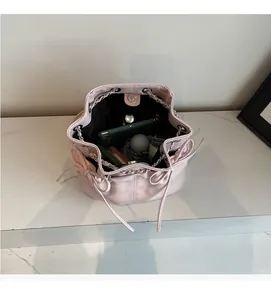 Macro view of a pink leather bucket bag showing large interior space for essentials