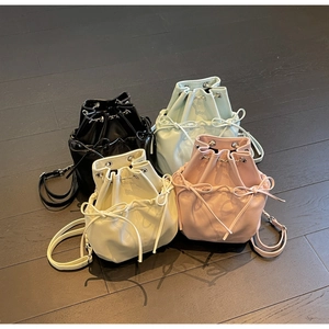 Top view of bucket backpacks with drawstring bows in black, blue, beige, and pink colors