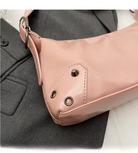 Detail der rosa Mondsichel-Tasche mit matter Lederstruktur und Vintage-Metallnieten