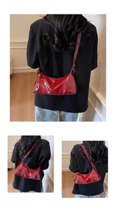 Detail der roten Lackleder-Schultertasche mit Silbernieten und verstellbarem Gurt