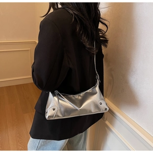 Detailsicht der silbernen Metallic-Schultertasche mit Nieten und langem Reißverschluss