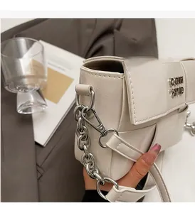 Détail du sac carré blanc en cuir tressé avec chaîne argentée et fermoir métallique