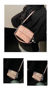 Détail d'un sac carré tressé rose avec chaîne argentée, logo et pendentif lapin