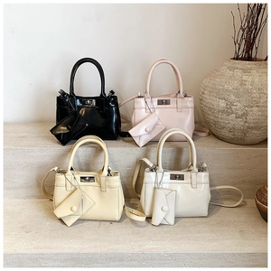 Detailed view of four colorful glossy leather handbags with decorative mini pouches
