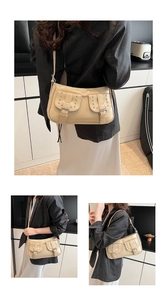 Detail of beige glossy PU shoulder bag featuring silver rivets and metal buckle pockets