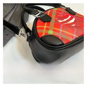 Nahaufnahme der Vintage-Karotasche mit rot-grünem Tartan und einem Apfel-Aufdruck