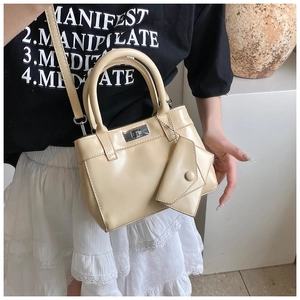 Detail of cream leather handbag with silver twist lock and mini envelope charm accessory