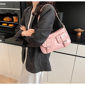 Pink glossy patent leather underarm bag with silver studs and buckles on model
