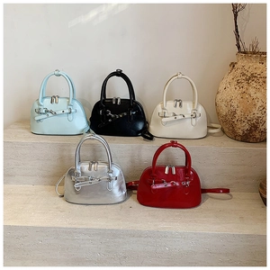 Detailed collection of shiny leather shell bags in five colors on stone steps display
