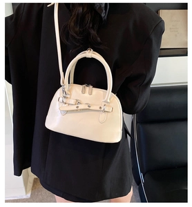 Detail view of cream vintage Boston bag with leather straps and metal hardware