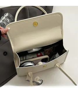 Spacious interior of cream PU leather tote bag with gold magnetic clasp and essentials