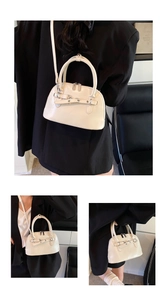Close-up of cream shell tote bag with belt detail, silver hardware, and adjustable strap