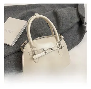 Close-up of cream PU leather handbag with belt buckle detail and silver hardware accents