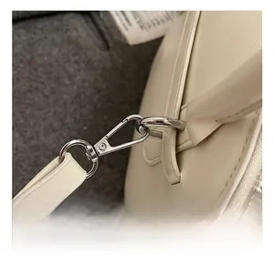 Close-up of premium silver metal hooks and zipper detail on the cream leather shell bag