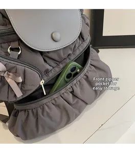 Detailed close-up of a pleated nylon backpack with a zipper pocket for phone storage