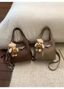 Detail of lychee pattern leather bucket bags with metal twist locks and teddy bear charms