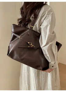Detail of vintage coffee brown tote bag with premium leather texture and gold hardware