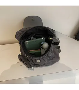 Top view of spacious interior of grey pleated backpack holding tablet, phone and umbrella