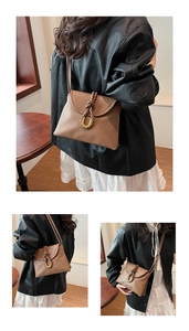 Close-up of brown leather handbag featuring a woven rope detail and gold U-shaped buckle