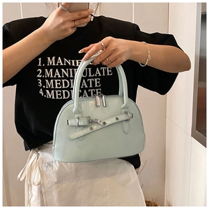 Close-up of mint green shell handbag with silver hardware and polished glossy finish