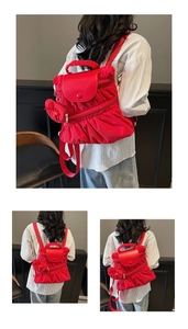 Macro detail of red ruched nylon backpack with matching puff handle and pendant bag