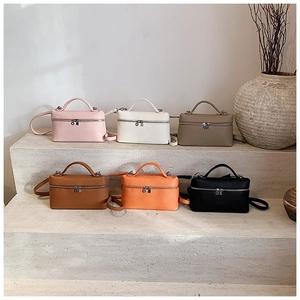 Variedad de bolsos minimalistas de cuero PU en múltiples colores mostrados en escalones de piedra